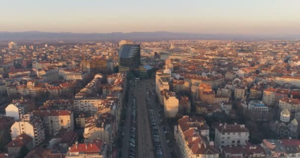 Boulevard v Sofii Bulharsko s městskou dopravou a moderní architektonickou budovou při západu slunce — Stock video