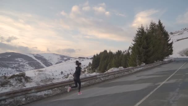 Mujer enérgica corriendo a la cima de la montaña, al Arco de la Libertad en Bulgaria en el invierno — Vídeo de stock