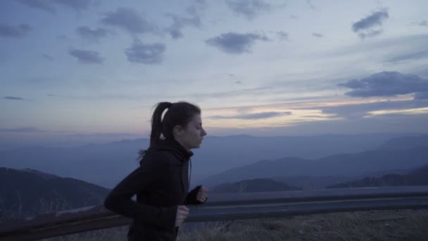 Mujer agotada corriendo, corriendo en la montaña al atardecer llegando a la cima — Vídeo de stock