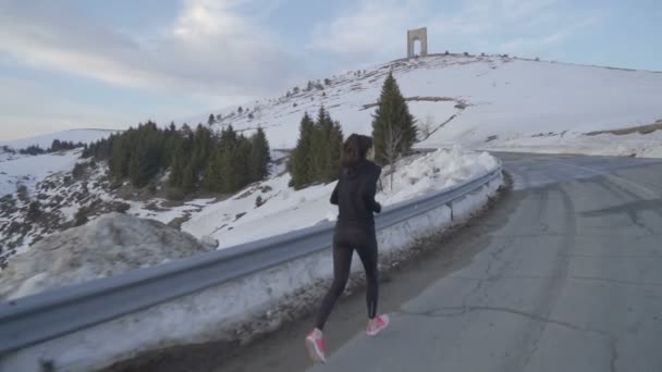 Ung fitness kvinna jogging i berget med båge av frihet i bakgrunden — Stockvideo