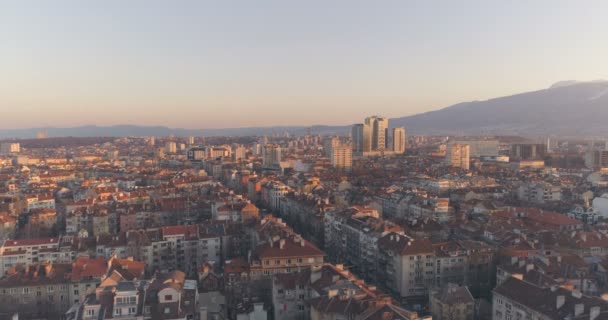 Daken van woongebouwen en kantoorgebouwen bij zonsondergang. Sofia, Bulgarije vanuit de lucht bekeken — Stockvideo