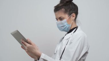 Kağıt hasta semptomlarına maske takmış bir kadın doktor. Covid-19, koronavirüs tedavisi