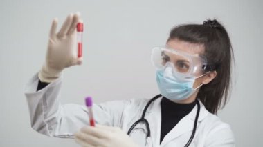 Tıbbi tesiste koronavirüs aşısı denemeleri. Kadın doktor kan örneklerini Covid-19 ile test ediyor.
