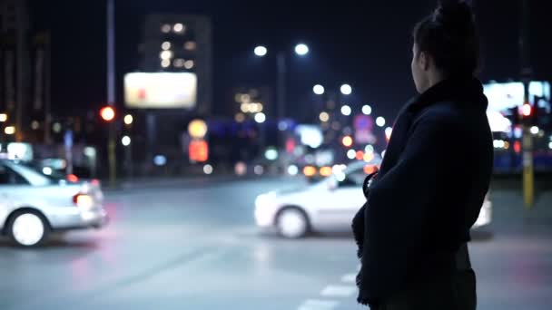 En kall ensam tjej som väntar på någon på gatan på natten. Att se sidled — Stockvideo