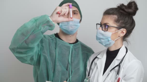 Chirurg a lékař s facemasks při pohledu na pacienta Krevní vzorek a testy — Stock video