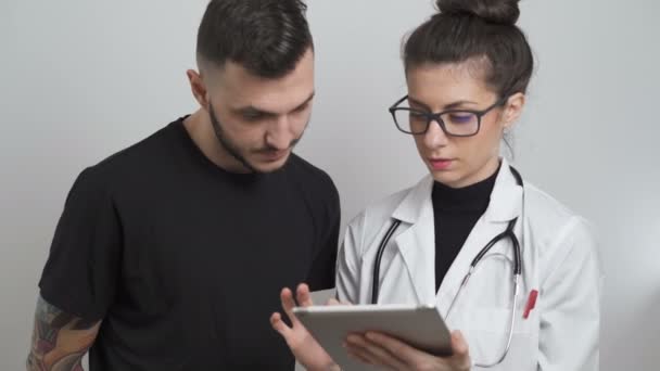 Médico femenino explicando los resultados de las pruebas médicas al paciente masculino — Vídeo de stock