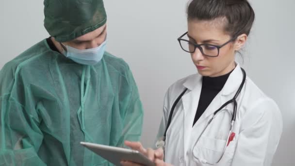 Cirurgião e médico falando sobre os sintomas dos pacientes considerando a ameaça — Vídeo de Stock