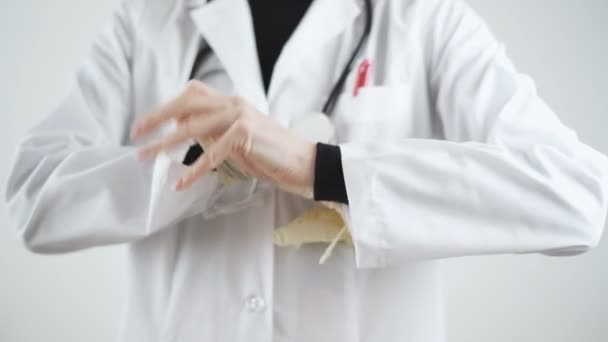 Доктор надел стерильные белые перчатки на рукав белого пальто — стоковое видео