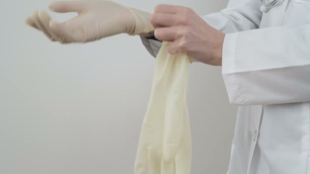 Врач показывает, как надеть латексные перчатки для базовой защиты от коронавируса — стоковое видео