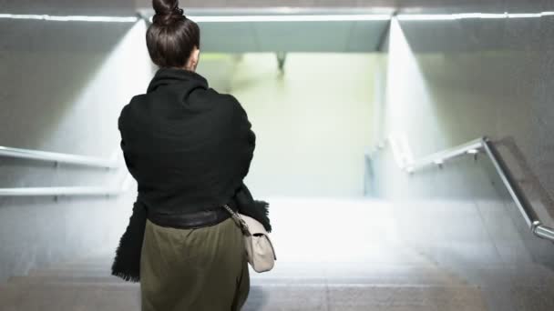 Una mujer que baja sola por las escaleras del metro. Luces brillantes brillando la entrada del metro — Vídeos de Stock