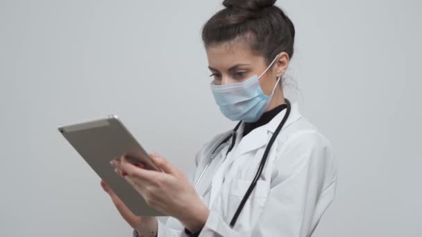 Giovane medico femminile annotando i sintomi del paziente in laboratorio per la malattia coronavirica — Video Stock