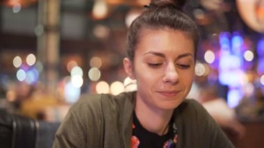 Genç bir kadın yemek çubuklarıyla Asya yemeklerini tadıyor. Heyecanlı kız yeni yemek deniyor.