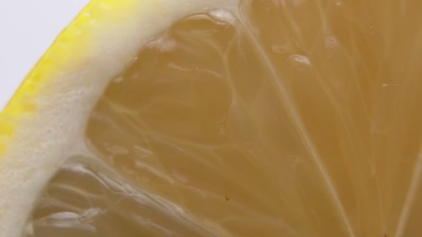 Макро застрелили щойно нарізаного лимона. Яскраві жовті сегменти лимона і тонка шкіра — стокове відео