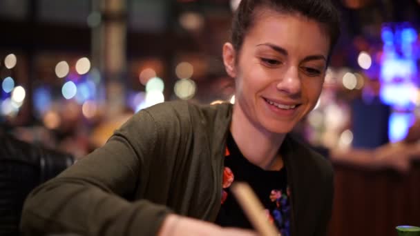 Belle fille souriant tout en prenant de la nourriture à l'aide de baguette — Video