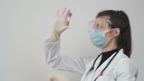 Bir tıbbi tesiste hastaların kan örneklerini tutan kadın doktor. Coronavirus testleri laboratuvarda yapılıyor.. — Stok video