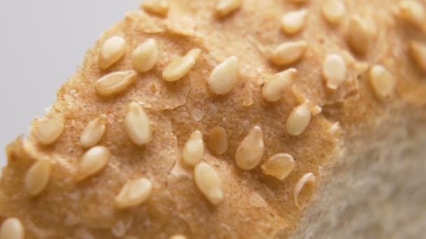 Graines de sésame sur une croûte brune de pain. Pain blanc tranché frais macro — Video