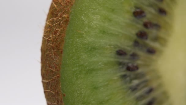 Закрываем киви ломтиками фруктов на белом фоне — стоковое видео
