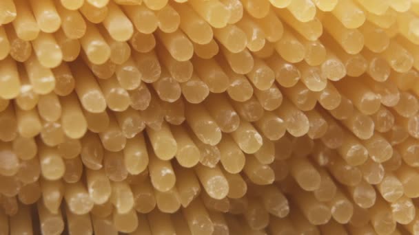 Close-up van een stel ongekookte gedroogde spaghetti, noedels. Italiaanse pasta achtergrond — Stockvideo