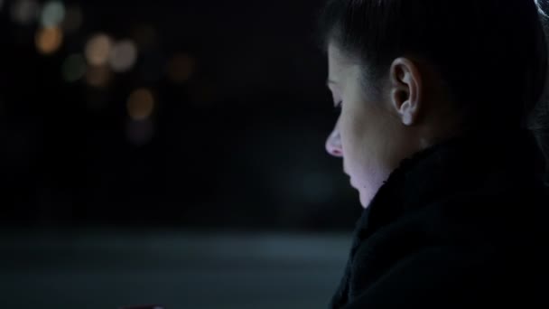 Otobanda oturan yalnız bir kadın cep telefonu kullanıyor ve birini bekliyor. — Stok video