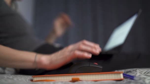 Naher Blick der Frau Hand mit der Maus während der Arbeit am Laptop im Bett liegend — Stockvideo