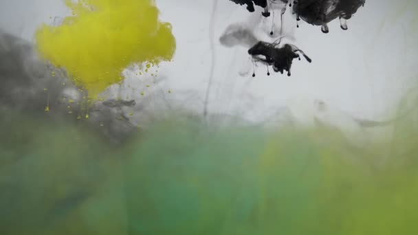 Zwarte, groene en gele verf inkt druipt in het water. Chemische reactie onderwater concept — Stockvideo