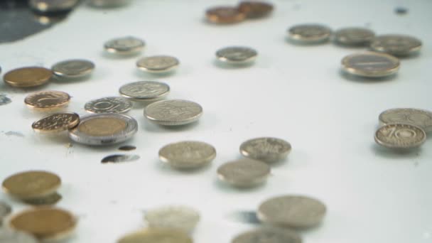 Banda monet wpadających do wody tworzących bąbelki i uderzających w inne monety na dole — Wideo stockowe