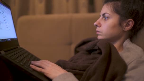 Jonge gefocuste vrouw die thuis op laptop werkt tijdens quarantaine — Stockvideo