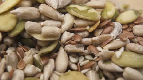 Las semillas de sésamo, girasol y calabaza se cierran. Montón de semillas comestibles sin cáscara de fondo — Vídeos de Stock