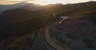 Güneşin batışı dağlarda uzak bir yolda.