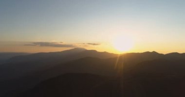 Karanlık dağların tepelerinde parlayan altın güneş