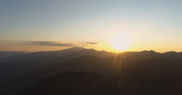 Sol dorado brillando sobre picos oscuros de montaña — Vídeos de Stock