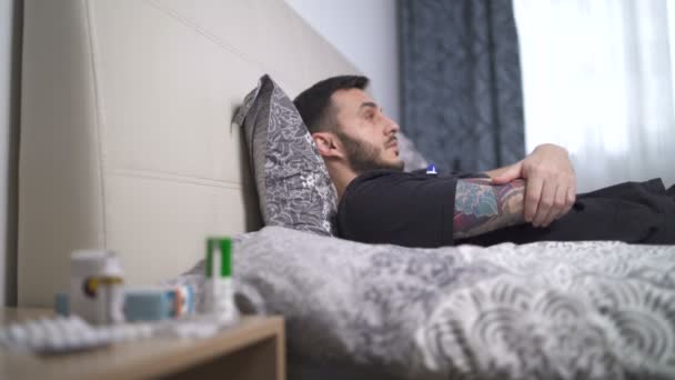 Unavený mladý muž ležící celé dny v posteli během domácí karantény — Stock video