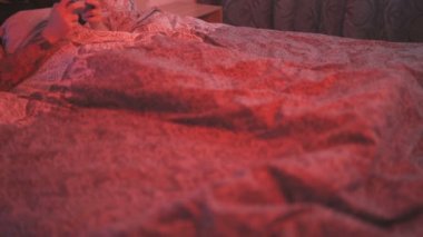 Heyecanlı ve kendinden geçmiş siyah yüzlü genç adam video oyununda kazandıktan sonra yatakta uzanıyor ve tezahürat yapıyor.