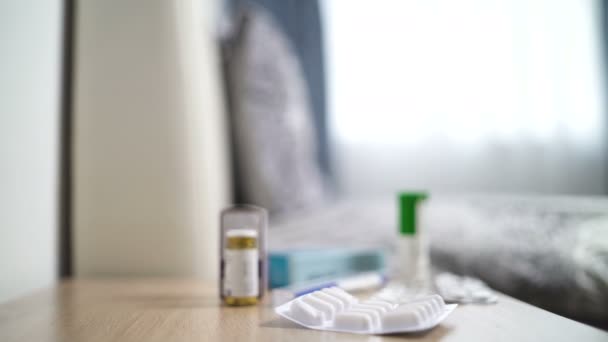 Близький вигляд блістера з білими таблетками на дерев'яній підставці в спальні — стокове відео