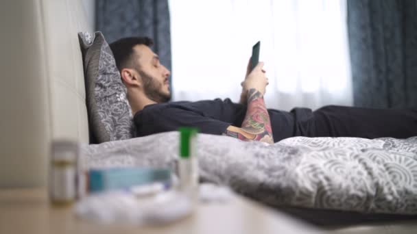 Man speelt op zijn telefoon tijdens quarantaine. Blijf thuis. — Stockvideo