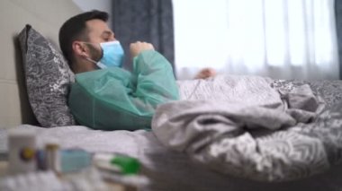 Hasta, öksüren, ateşi olan, mavi maskeli bir adam.