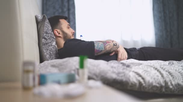 Hombre enfermo midiendo la temperatura con termómetro electrónico en la cama — Vídeos de Stock