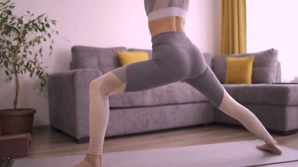 Femme en position de yoga, les bras tendus, regardant de côté — Video