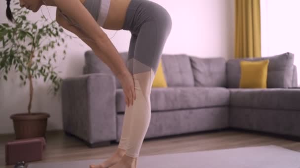 Femme flexible étirant le bas du dos faisant du yoga à la maison. Fille faisant Halasana pose de yoga — Video