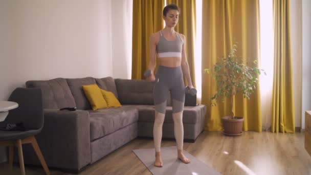 Schöne Frau macht Cardio mit Kurzhanteln — Stockvideo