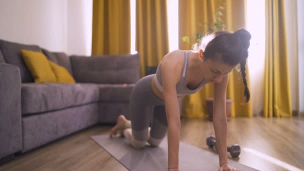 穿着运动服的女人在家里做瑜伽垫俯卧撑 — 图库视频影像