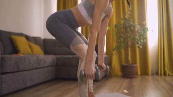 Hälsosam flexibel flicka hem träning med vikter — Stockvideo