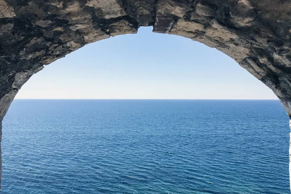 Eski taş kemer. Kemer boyunca deniz ve gökyüzü manzarası
