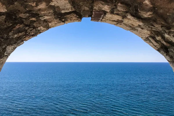 old stone arch. view of the sea and sky through the arch