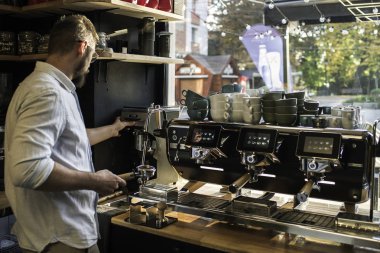 Kahve makinesinde kahve yapan barista.