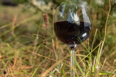  Arka planda bir kadeh kırmızı şarap var.