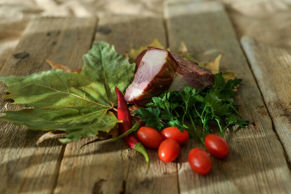  овощи и копченое мясо на столе
