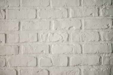 Odanın içinde beyaz tuğla duvar var.