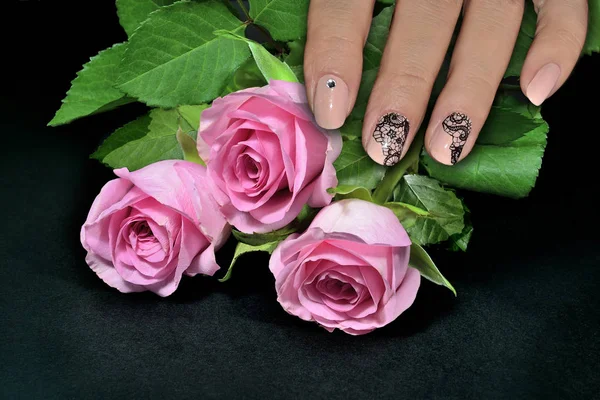 Mão feminina com manicure prego arte e rosas rosa — Fotografia de Stock