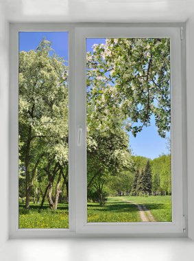 Pencerenin altında bahar ağaçları çiçek açan